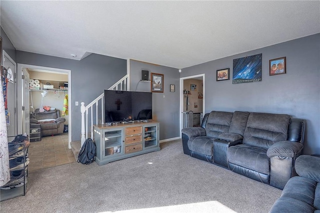 carpeted living area featuring stairs