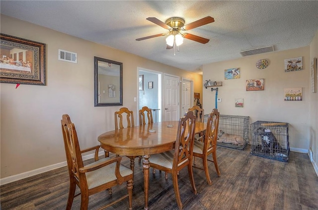 dining area featuring dark wood finished floors, visible vents, a textured ceiling, and ceiling fan