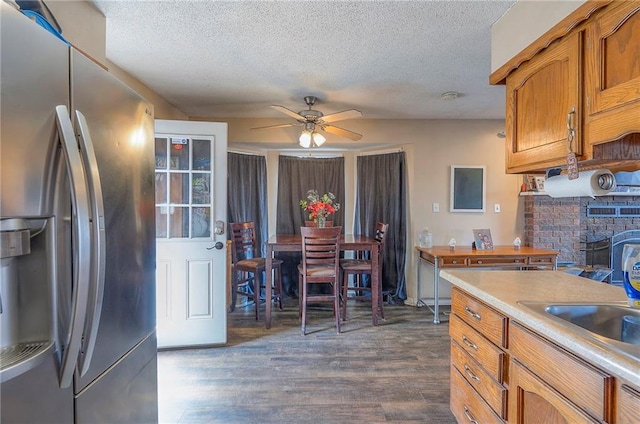 kitchen featuring brown cabinetry, stainless steel fridge, dark wood finished floors, and a ceiling fan