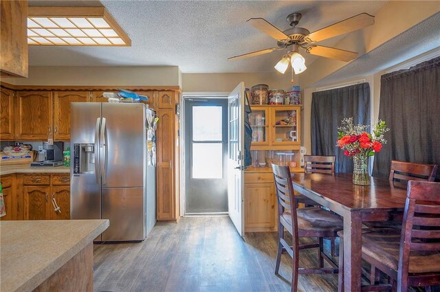 kitchen with light countertops, light wood-style flooring, brown cabinetry, and stainless steel fridge