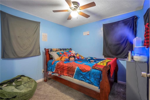 carpeted bedroom with ceiling fan, baseboards, and a textured ceiling