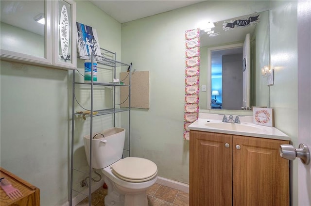 half bathroom featuring baseboards, toilet, and vanity