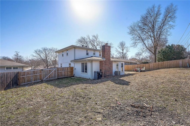 rear view of property with a chimney and a fenced backyard