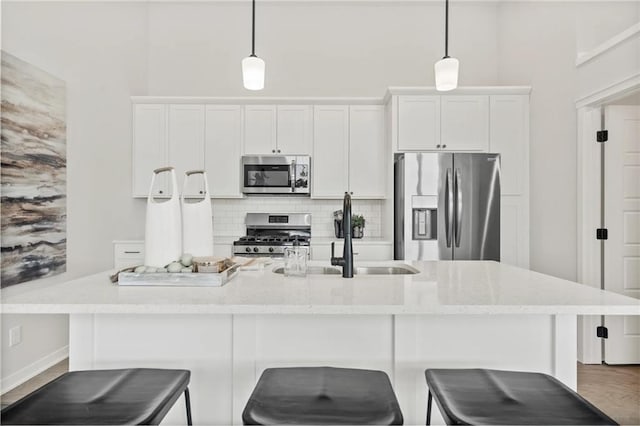 19712 W 195th Pl, Spring Hill, KS 66083 - kitchen featuring stainless steel appliances, tasteful backsplash, a center island with sink, white cabinetry, and a towering ceiling