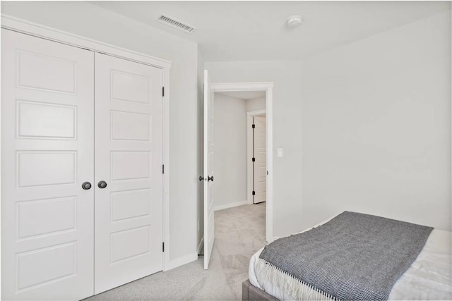 bedroom featuring light colored carpet and a closet