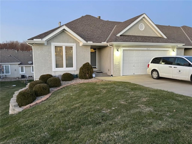 single story home with a garage and a front lawn