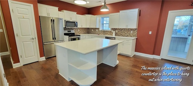 kitchen featuring pendant lighting, a center island, stainless steel appliances, and white cabinetry