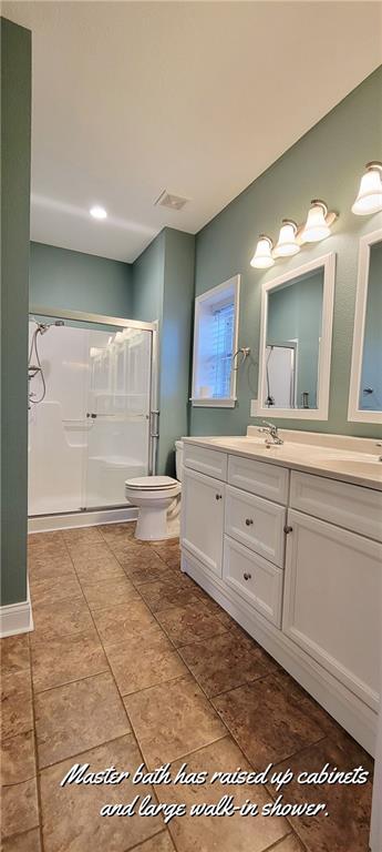 bathroom featuring vanity, an enclosed shower, and toilet