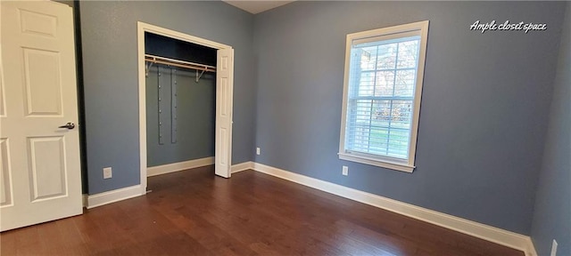 unfurnished bedroom with dark hardwood / wood-style floors and a closet