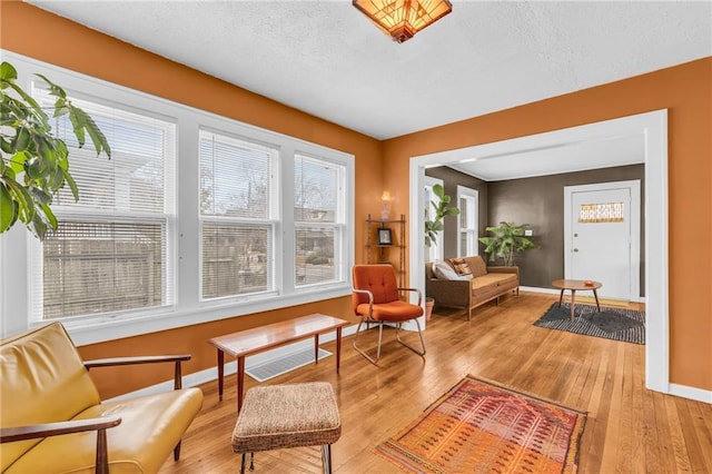 sitting room with light hardwood / wood-style flooring and a textured ceiling