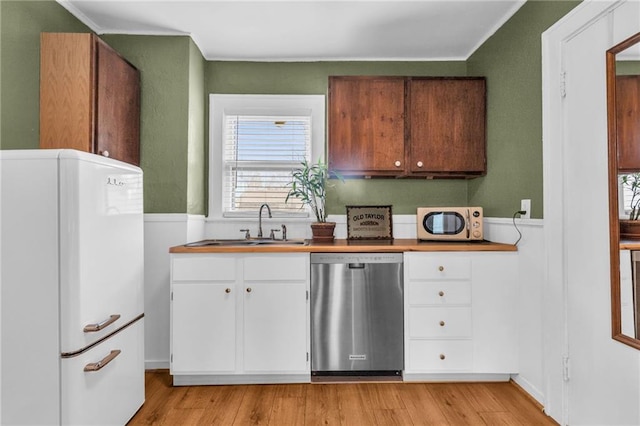 kitchen featuring white cabinetry, light wood-type flooring, white appliances, and sink