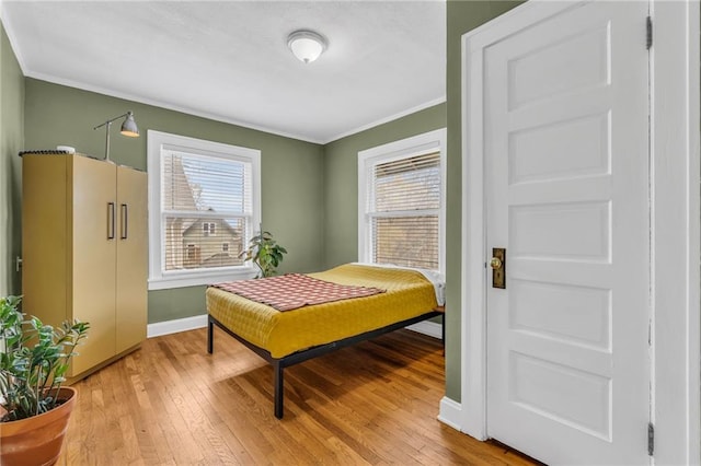 bedroom featuring crown molding and light hardwood / wood-style flooring