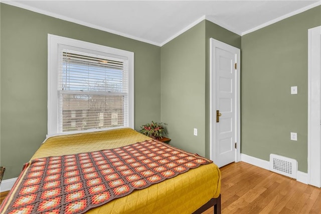 bedroom with hardwood / wood-style floors and ornamental molding