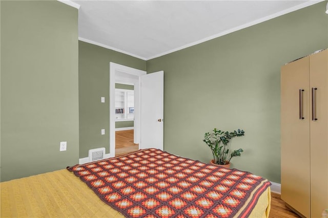 bedroom with light hardwood / wood-style floors and ornamental molding