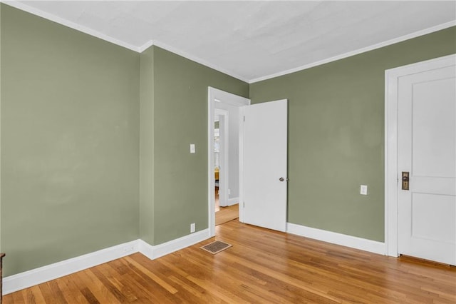 unfurnished room with crown molding and wood-type flooring