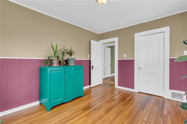 foyer with light wood-type flooring and ornamental molding