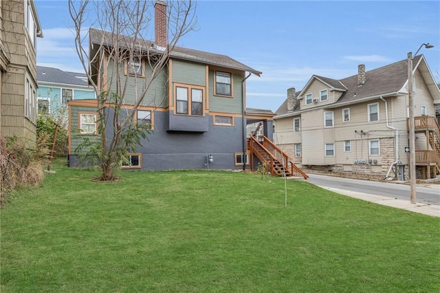 rear view of house featuring a lawn