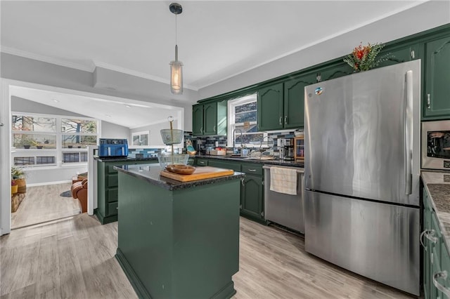 kitchen featuring appliances with stainless steel finishes, a center island, vaulted ceiling, and green cabinetry