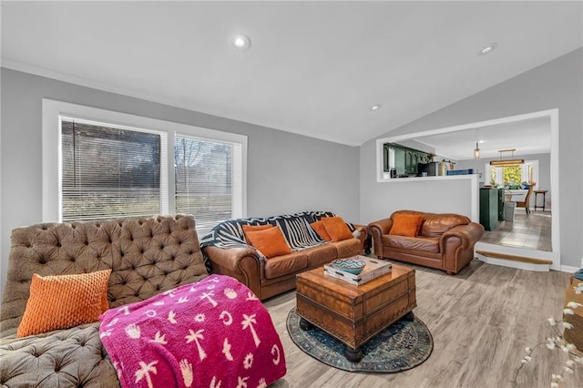 living room with light hardwood / wood-style floors, a healthy amount of sunlight, and lofted ceiling