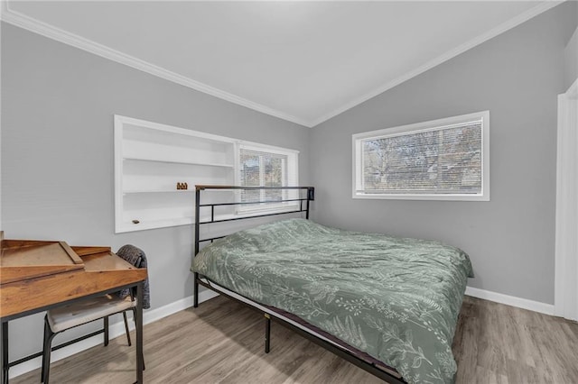 bedroom featuring crown molding, lofted ceiling, and hardwood / wood-style flooring