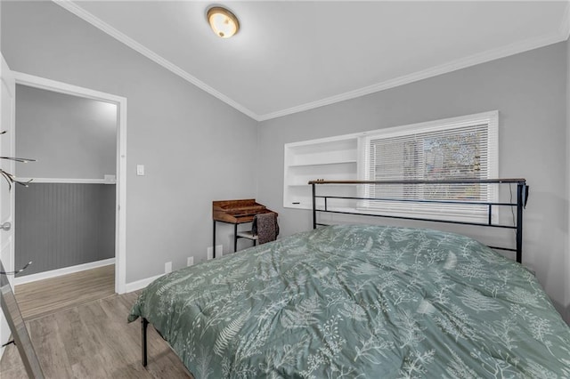 bedroom featuring hardwood / wood-style flooring, crown molding, and vaulted ceiling