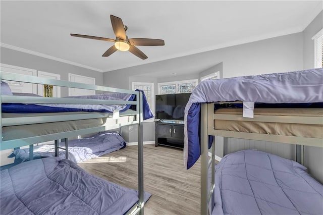 bedroom with ceiling fan, crown molding, and wood-type flooring