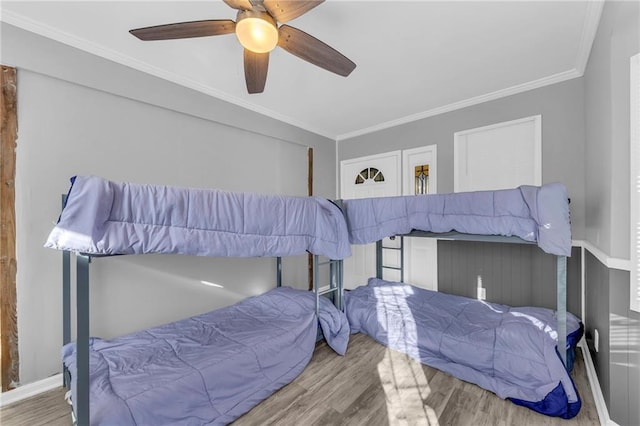 bedroom featuring hardwood / wood-style floors, ceiling fan, and ornamental molding