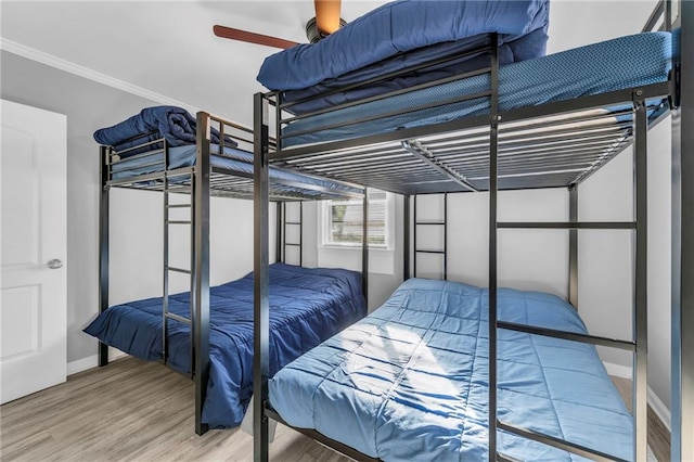 bedroom featuring ceiling fan, hardwood / wood-style floors, and ornamental molding