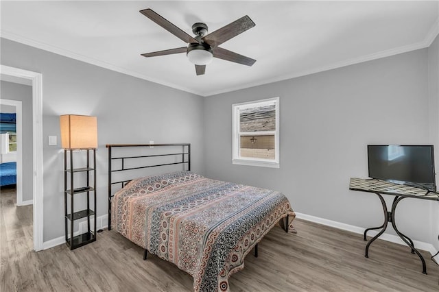 bedroom featuring light hardwood / wood-style flooring, ceiling fan, and crown molding