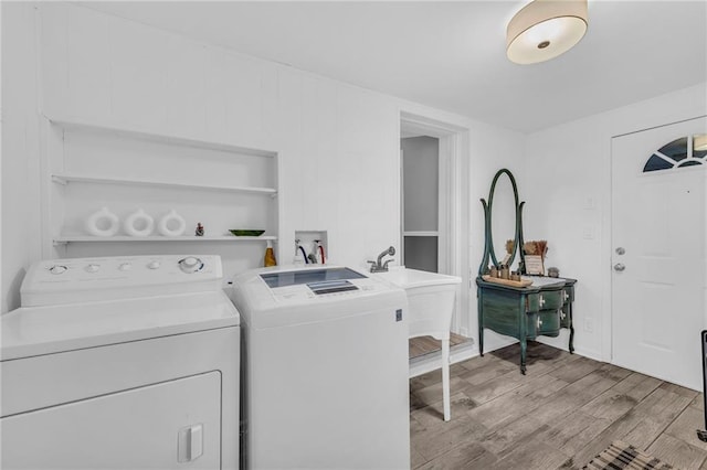 laundry room featuring washer and dryer, light wood-type flooring, and sink