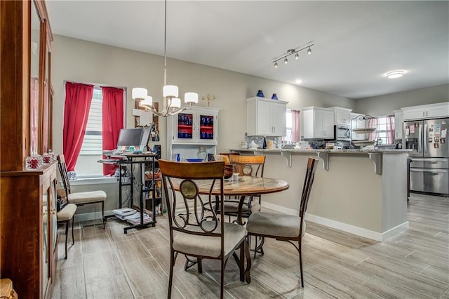 dining area featuring a notable chandelier, a healthy amount of sunlight, and light hardwood / wood-style floors