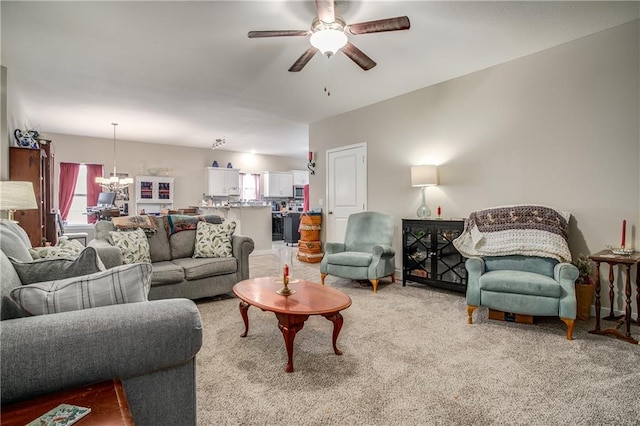 carpeted living room with ceiling fan with notable chandelier