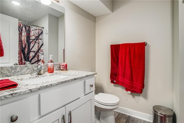 bathroom featuring hardwood / wood-style flooring, toilet, and vanity