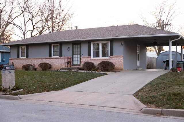 ranch-style home with a carport, a storage unit, and a front lawn