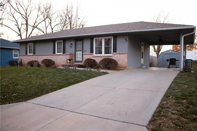 ranch-style house featuring a carport, a storage unit, and a front lawn