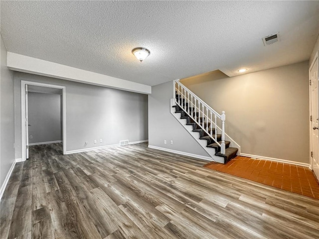 basement with a textured ceiling and hardwood / wood-style flooring