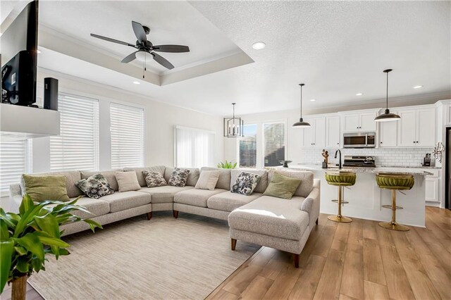 20915 W 190th Ter, Spring Hill, KS 66083 - living room featuring light wood-type flooring, ceiling fan, ornamental molding, recessed lighting, and a tray ceiling