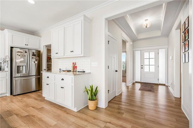 20915 W 190th Ter, Spring Hill, KS 66083 - kitchen with stainless steel refrigerator with ice dispenser, ornamental molding, tasteful backsplash, white cabinetry, and light wood finished floors