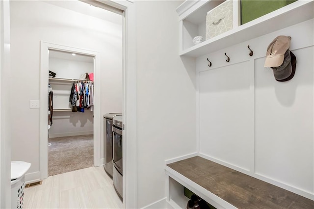 mudroom featuring light carpet and washing machine and clothes dryer