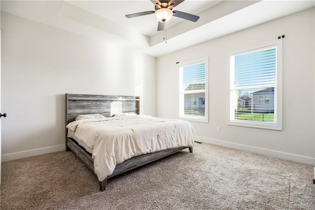 bedroom featuring carpet, ceiling fan, and a tray ceiling