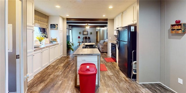 kitchen featuring black appliances, dark hardwood / wood-style flooring, a center island, and white cabinets