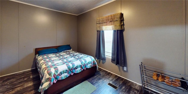 bedroom with crown molding and dark wood-type flooring