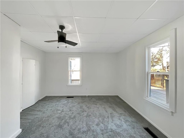 unfurnished room featuring carpet flooring, ceiling fan, and a drop ceiling