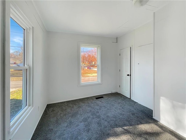 carpeted spare room featuring plenty of natural light