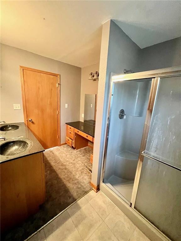 bathroom with tile patterned flooring, vanity, and walk in shower