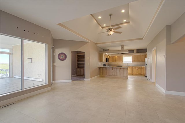 kitchen featuring ceiling fan, light tile patterned flooring, kitchen peninsula, and a tray ceiling