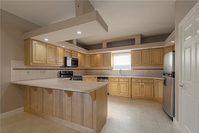 kitchen with kitchen peninsula, appliances with stainless steel finishes, backsplash, a kitchen breakfast bar, and light brown cabinets