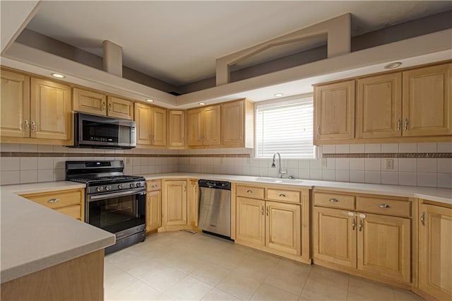 kitchen with light brown cabinetry, stainless steel appliances, tasteful backsplash, and sink