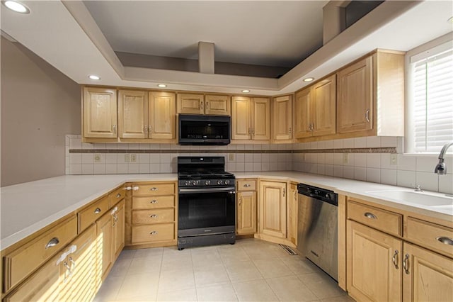 kitchen featuring light brown cabinets, sink, a raised ceiling, and black appliances