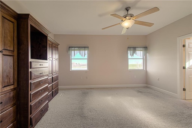 bedroom featuring ceiling fan, light colored carpet, and multiple windows